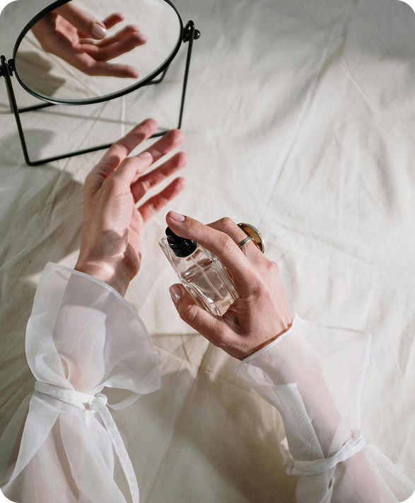spraying perfume on hands